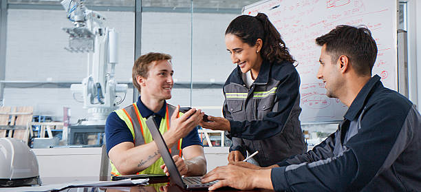istock White Latin industrial engineer man and woman work together, use speech recognition translator on smartphone in factory meeting room. Mechanical industry. Artificial Intelligence technology concept. 2232565023