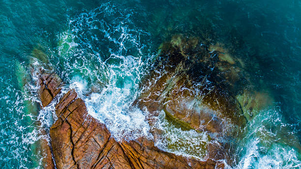 istock Turquoise sea laps a rugged, rocky coastline 2232573136