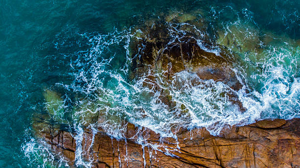istock Turquoise sea laps a rugged, rocky coastline 2232573179