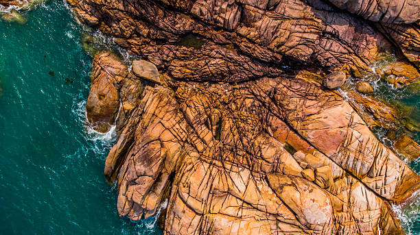 istock Turquoise sea laps a rugged, rocky coastline 2232573263