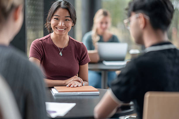 istock Smiling Young Woman Engages in Group Study Session at a Cafe 2232573355