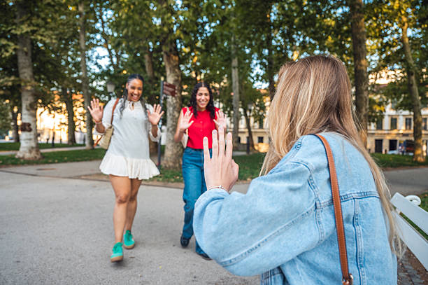 istock Young Friends Joyfully Greeting Each Other in Urban Park 2232573646