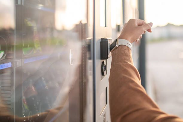 istock Young Caucasian Female Paying with Smartwatch at Vending Machine 2232574014