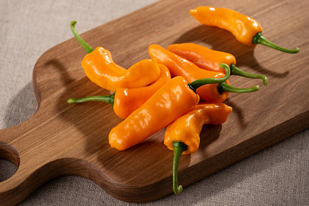 Fresh Yellow Orange Datil Chili Peppers Arranged on a Wooden Cutting Board