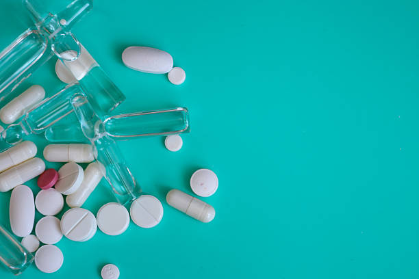 istock A composition of medical preparations—ampoules, tablets, and capsules—is placed on a turquoise background, creating space for text or other information. 2232575845