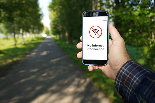 istock Man holding smartphone showing no internet connection in a park 2232578691
