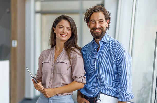 istock Business partners smiling and looking at camera in modern office 2232581313