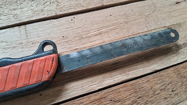 istock Close-up of a rusty hand saw on a wooden surface 2232585267