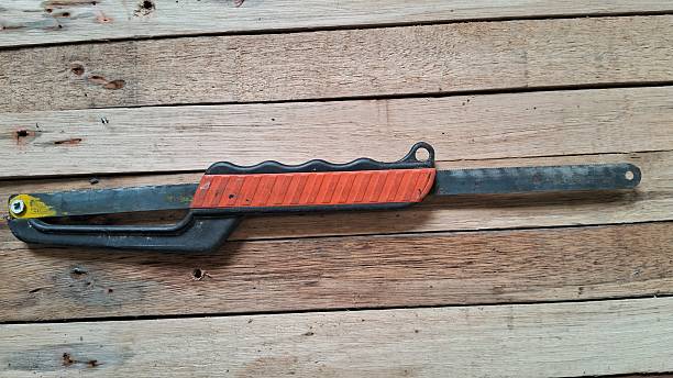 istock Hand Saw with Orange Handle on Wooden Planks 2232585281