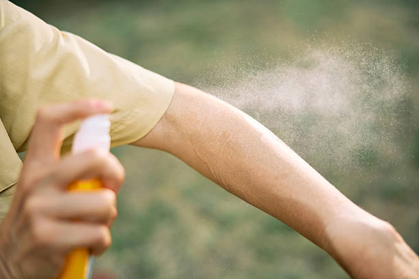 istock Arm Being Sprayed with Repellent Outdoors on a Sunny Day 2232591813