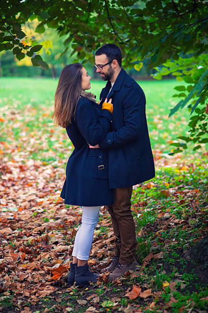 Young happy couple hugging in the forest on a beautiful autumn day.