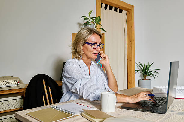 istock Smiling blond haired business woman taking notes while talking at phone in her workplace in office 2232595813