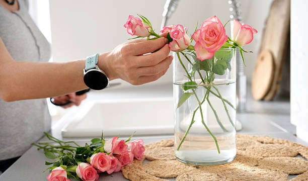 istock Woman Putting Roses In Vase 2232599312