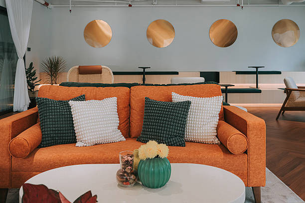 Stylish lounge area in a creative coworking office space, featuring an orange sofa, decorative cushions, and modern interior design. Location: Kuala Lumpur, Malaysia.