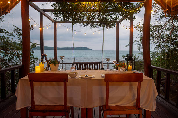 istock Romantic dinner setup on wooden terrace overlooking ocean at sunset 2232602464