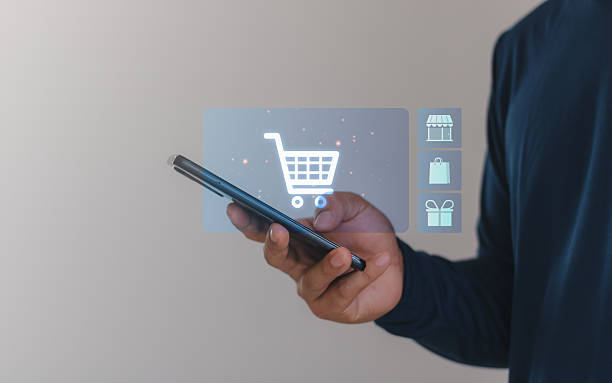 istock Hand holding smartphone with digital shopping cart icon, e-commerce technology, online retail, mobile shopping, digital payment, marketplace, buy and sell, internet store and consumer retail concept. 2232602903