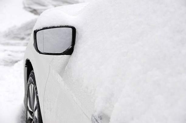 istock snow covered car with only side view mirror out 2232608631