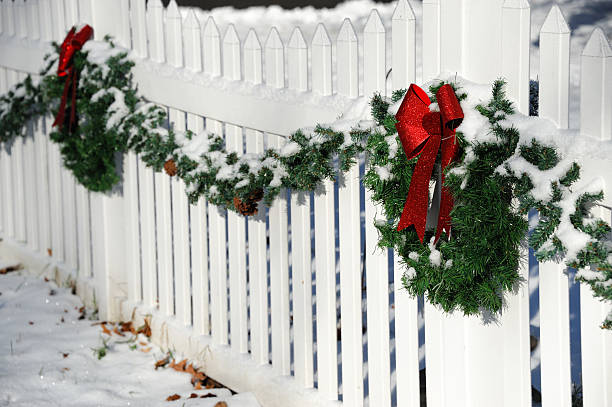 istock Christmas wreath hanging on white fence 2232608939