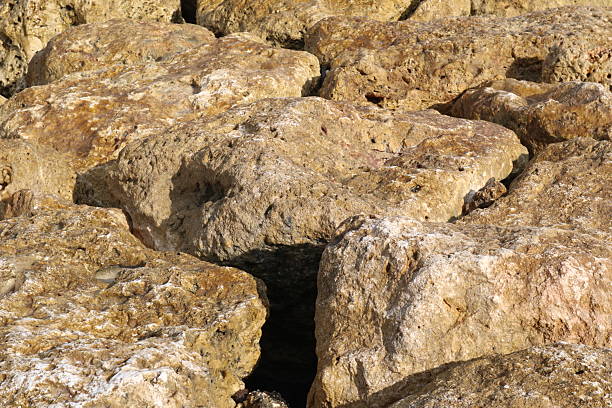 weathered and cracked rocks near Antalya  over blue sea water. Rocks consist of basalt stones with huge size and different colors , but mainly there are white and brown colors