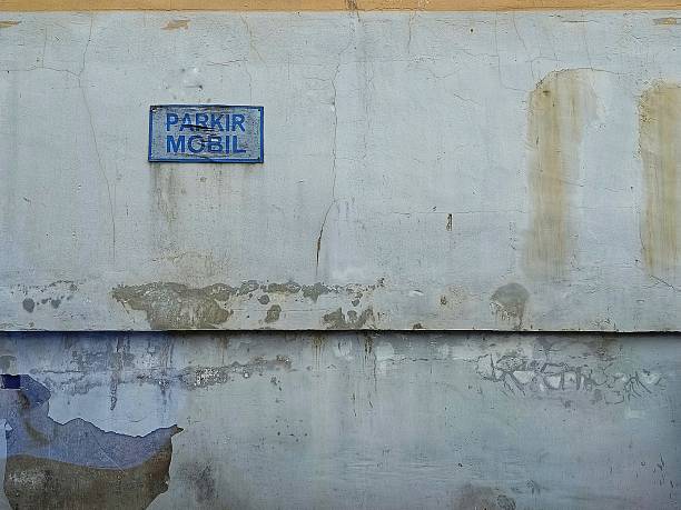 istock A weathered wall with a blue sign that reads “PARKIR MOBIL.” 2232613377