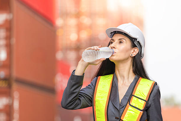 istock Hardworking Port Supervisors Staying Hydrated at a Shipping Terminal, Logistics Worker Taking a Water Break at a Container Yard, Female Engineers Overcoming Heat and Fatigue on the Job 2232614659