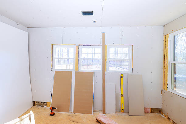 istock Drywall installation in bright room under construction with windows unfinished walls 2232615292