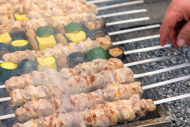 Grilled vegetables next to regular meat barbecue. courgette, eggplant