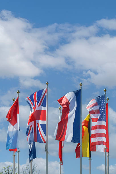 istock Flags of different west countries fluttering under a clear blue sky with scattered clouds on a sunny day 2232616840