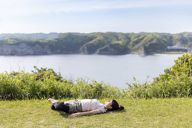 Female tourist lying down on grass field in empty island