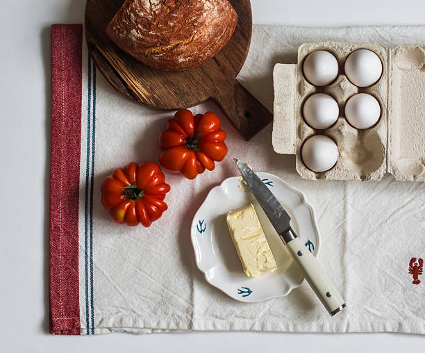 Breakfast ingredients - eggs, butter, fresh bread on the table, top view
