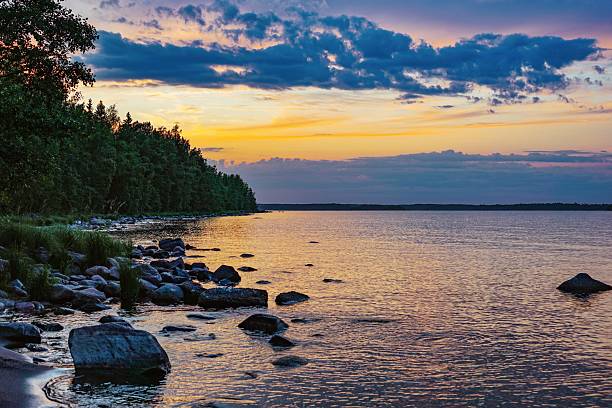 istock Sunset over Lake with Trees and Rocks 2232629550