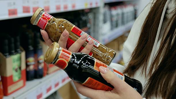 istock Customer comparing two sauce bottles in a supermarket and making a decision based on ingredients and nutrition facts while grocery shopping 2232629673
