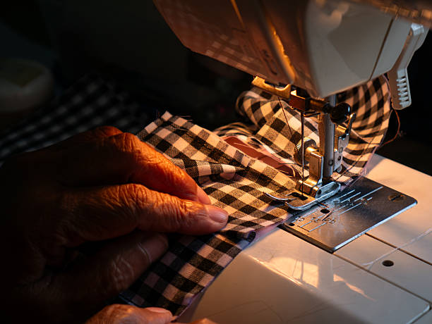 Senior Woman Working with Sewing Machine. Elderly Hands Creating Garments through Skilled Labor