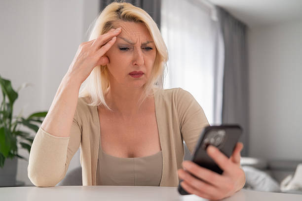istock Concerned woman looking at smartphone at home 2232631095