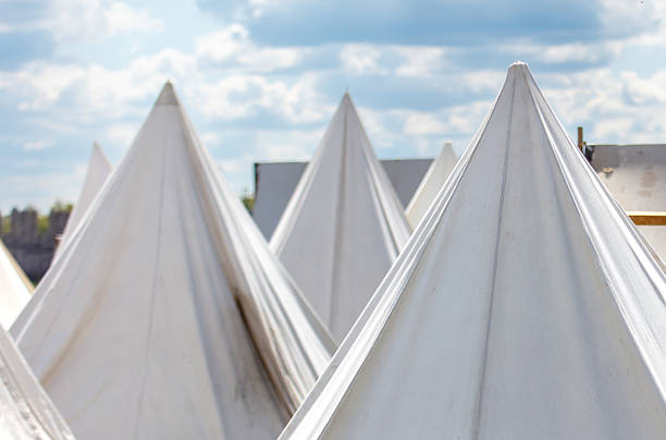 A row of tents with white fabric on top. The tents are all different sizes