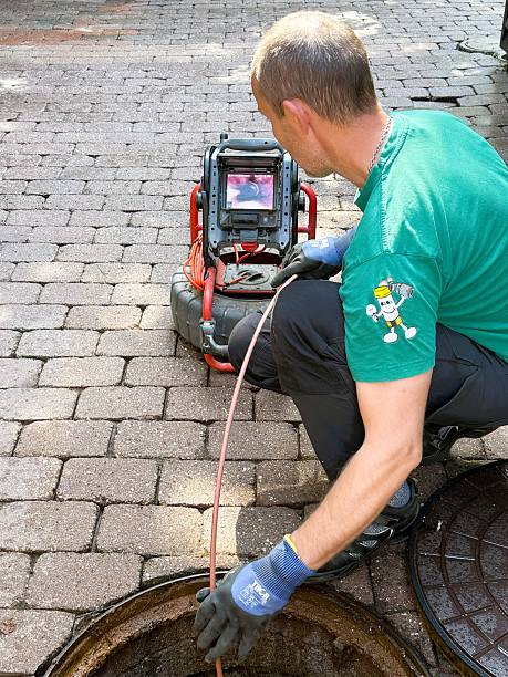 A maintenance worker uses a sewer inspection camera to check pipes in a residential building. Concept of plumbing service, pipe repair, and preventive home maintenance. The photo was taken on August 20 2025.