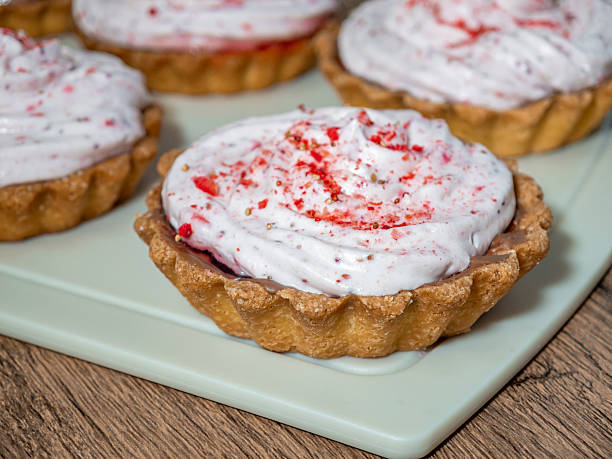 istock Mini sweet tarts filled with raspberry and strawberry cream, close-up 2232637350
