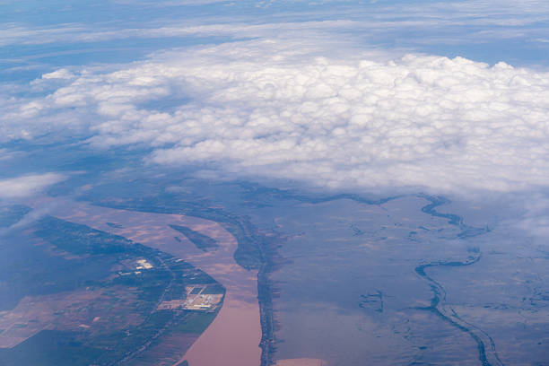 View from airplane window showing aircraft engine, blue sky, and white clouds. Aerial perspective symbolizing travel, vacation, freedom, and adventure. Somewhere in South Vietnam
