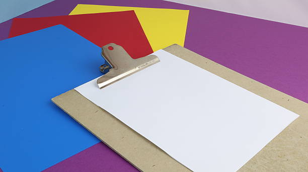 istock Blank sheet of paper held by clipboard with colored background and copy space 2232647818