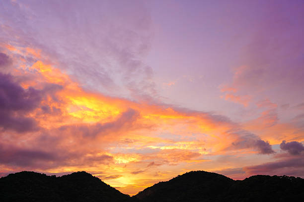istock sunset sky with dramatic purple, pink, and orange clouds over silhouette mountains. Captures peaceful nature and magical twilight moment for background, travel, and nature concepts. 2232649238