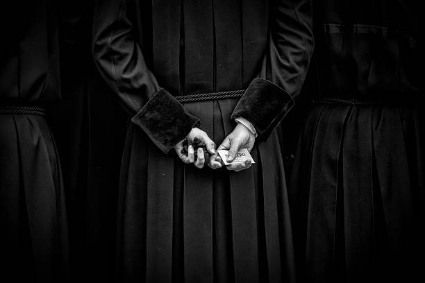 Leon, Spain. 14 April 2025. Close-up of the hands on the back of a brotherhood member during the Holy Week processions in Leon, Spain.