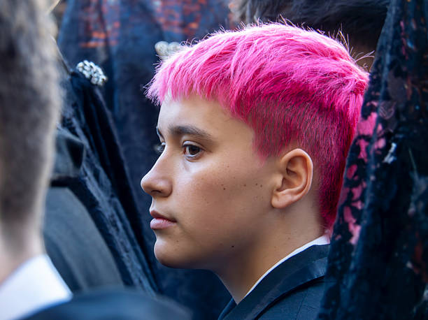 Leon, Spain. 14 April 2025. Close-up profile shot of a young man with reddish hair, waiting in the street to take part in the Holy Week processions in Leon, Spain.