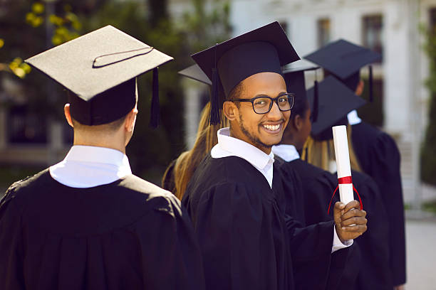 istock Half turned indian graduate man in graduation clothes looking at camera and smiling on ceremony. 2232652122