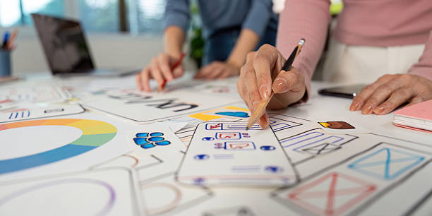 istock Hands on UX and UI Design. Team members sketching ideas and wireframes on a collaborative project. 2232658445