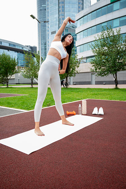 istock A young woman in a light-colored tracksuit is exercising outdoors on a summer day 2232660892
