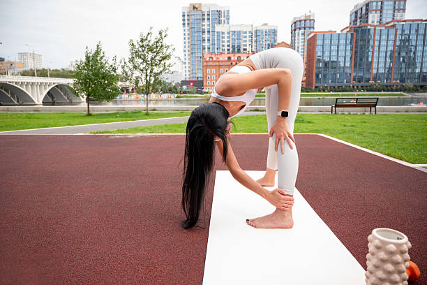istock A young woman in a light-colored tracksuit is exercising outdoors on a summer day 2232661255