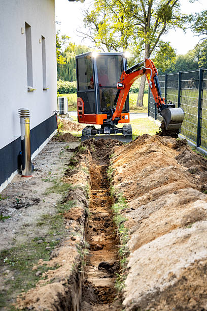 istock Mini excavator digging a trench next to a single family house 2232661637