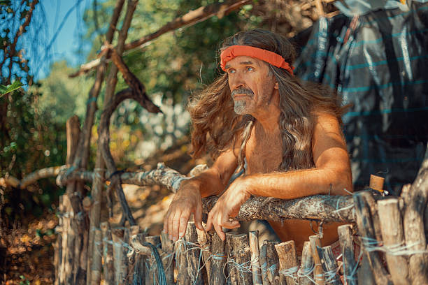 Hermit looking outside his wooden hut in the forest