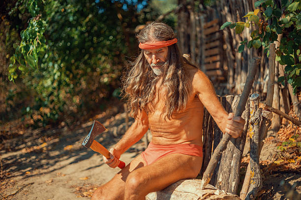 Modern hermit crafting wood with an axe in the forest