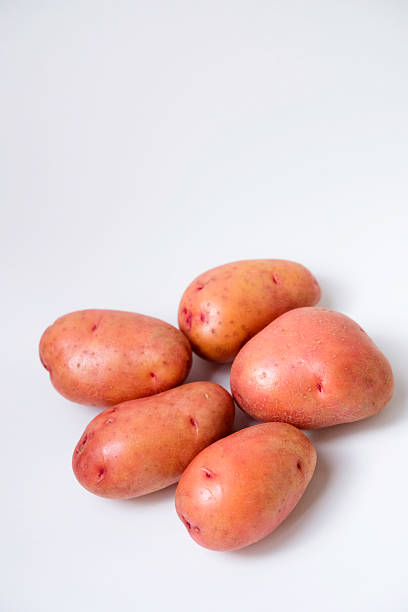 istock Selective focus of red potato on white background 2232664455